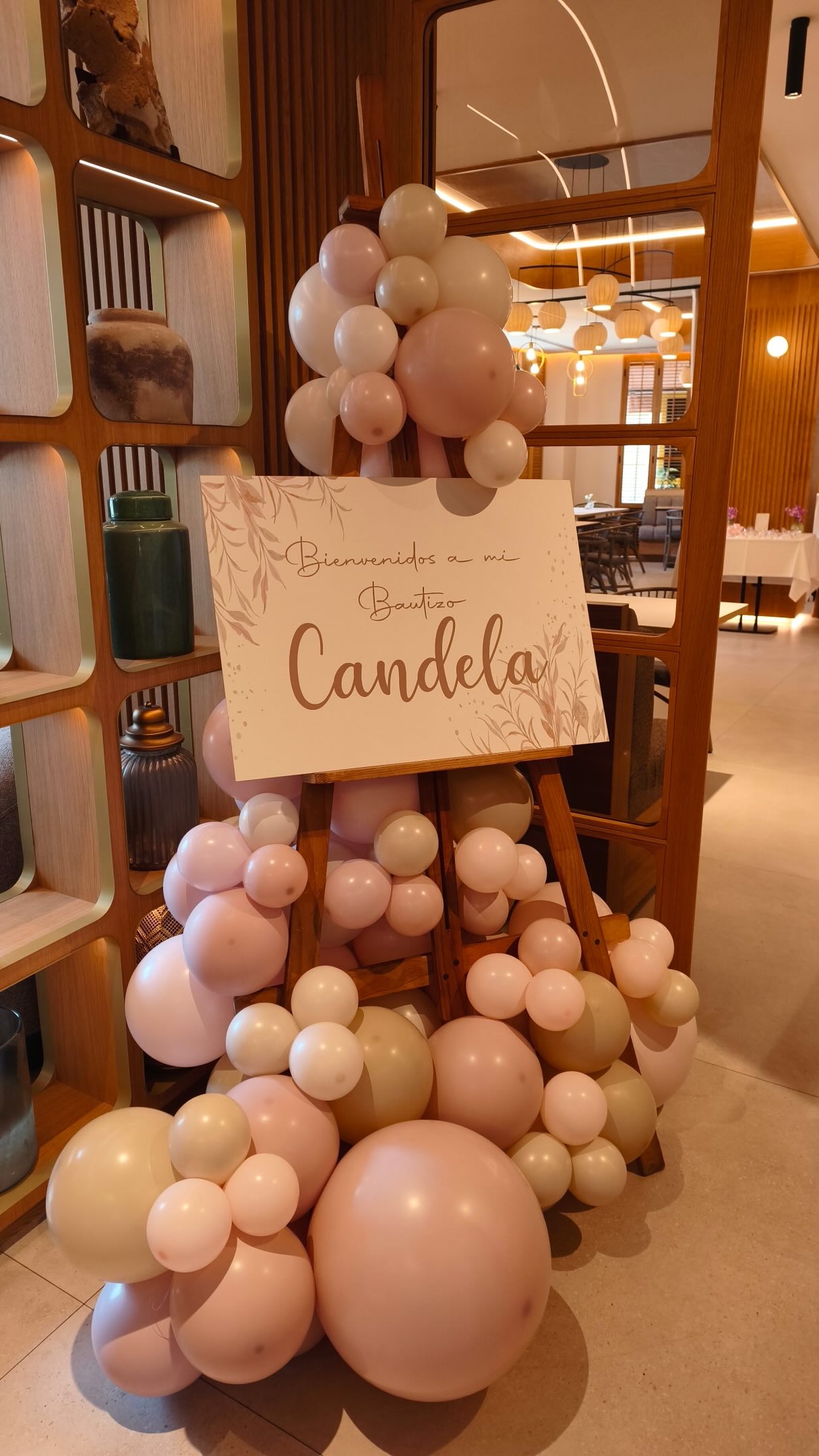 Rincón de bienvenida para el bautizo de Candela con cartel y globos rosa blanco y arena