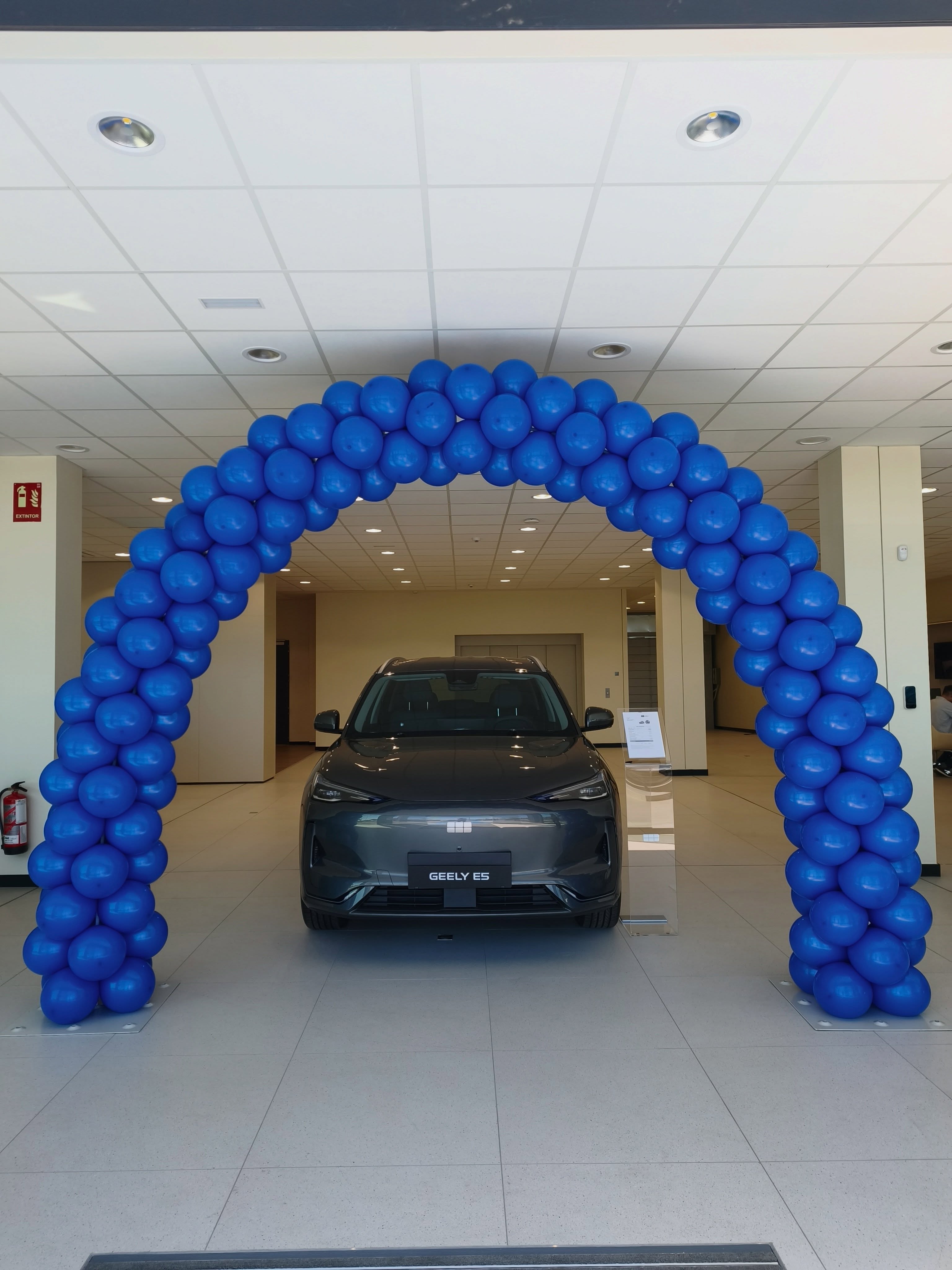 Coche Geely enmarcado por un arco de globos azul