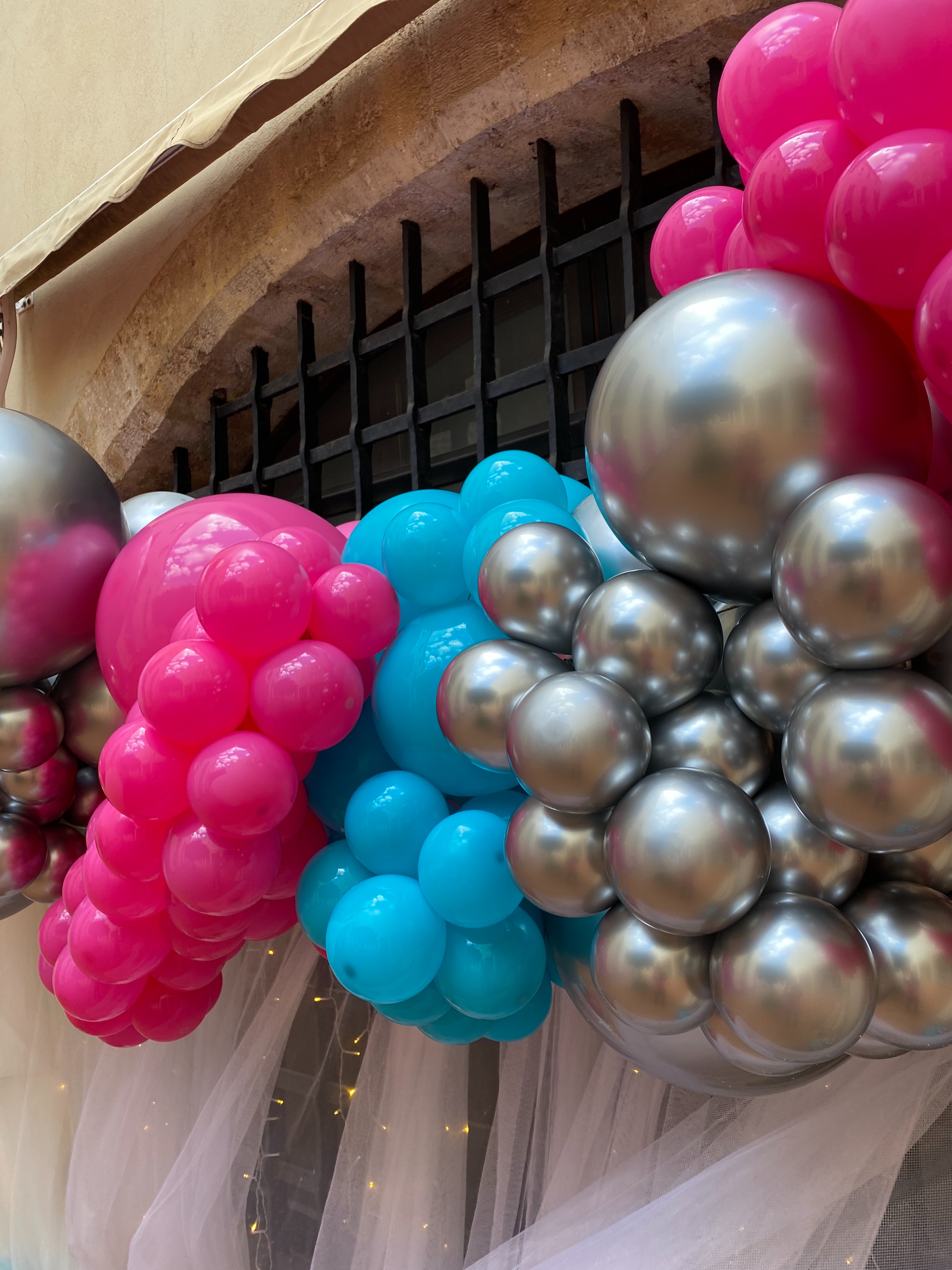 Detalle de globos metalizados y colores vivos en una decoración de graduación