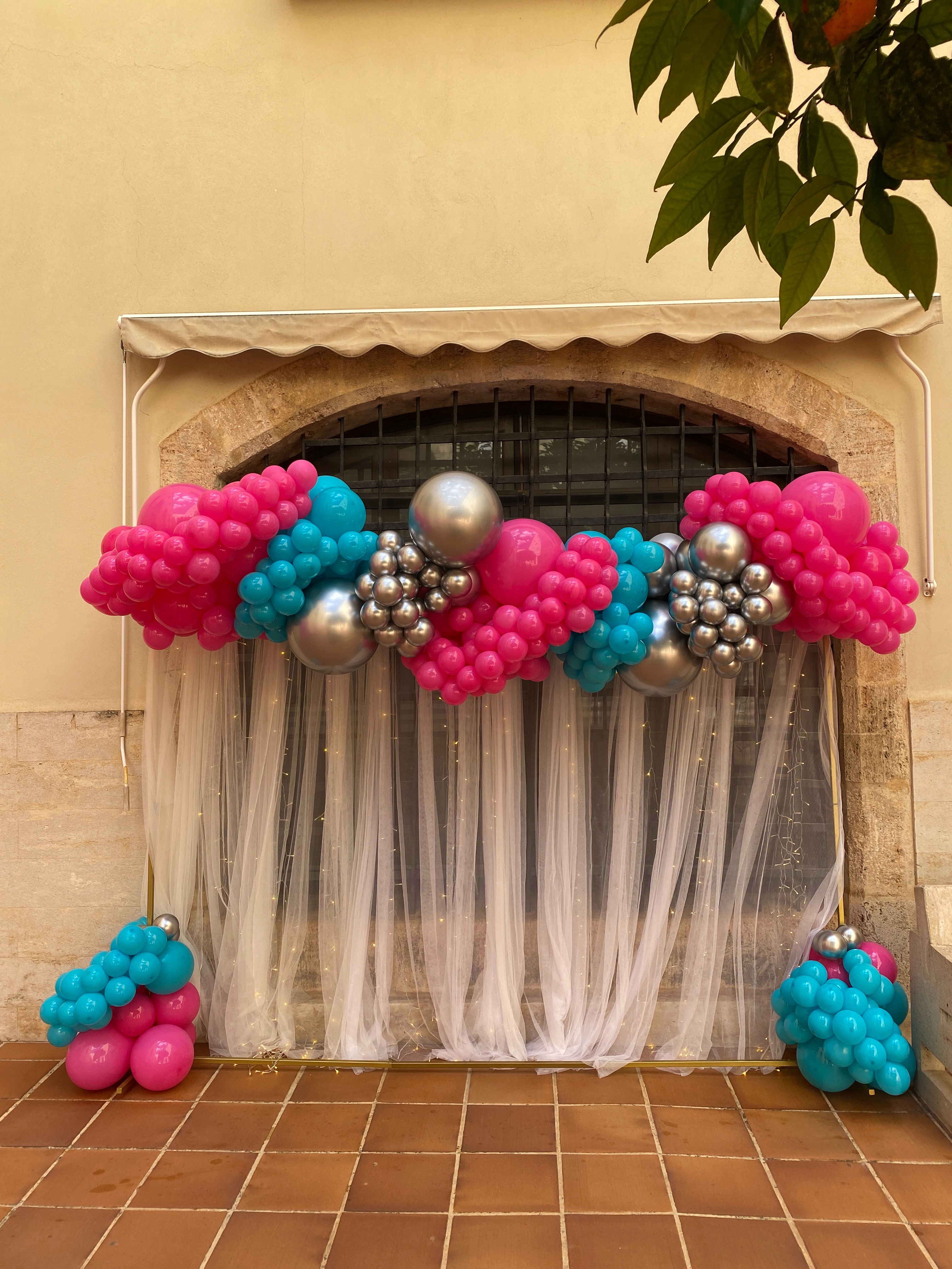 Decoración con globos fucsias, turquesas y plata para una graduación