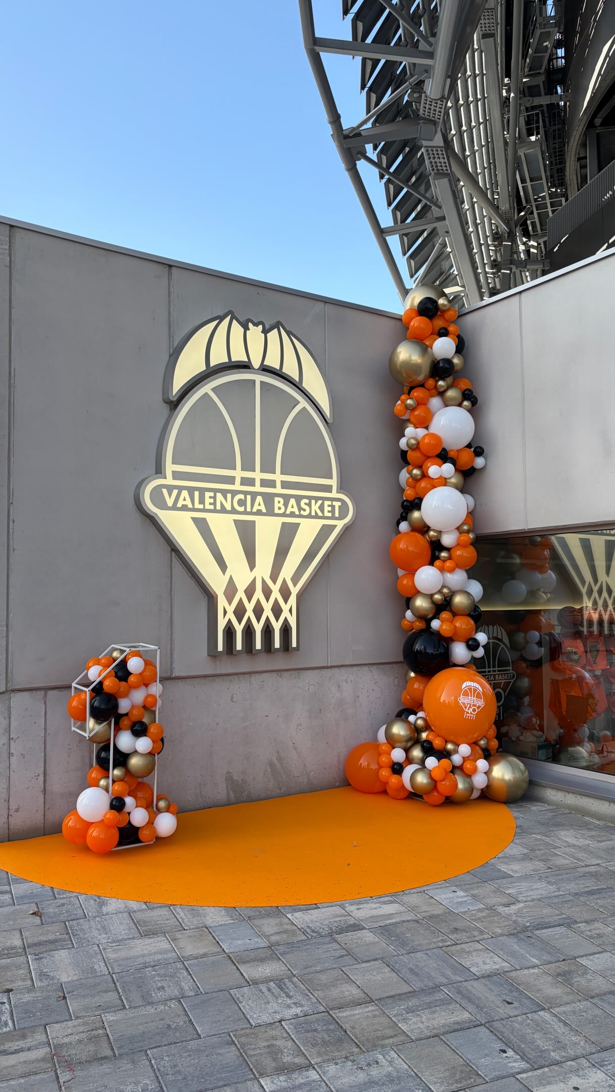 Decoración exterior para Valencia Basket con globos naranjas, negros, blancos y dorados y estructura con forma de 1