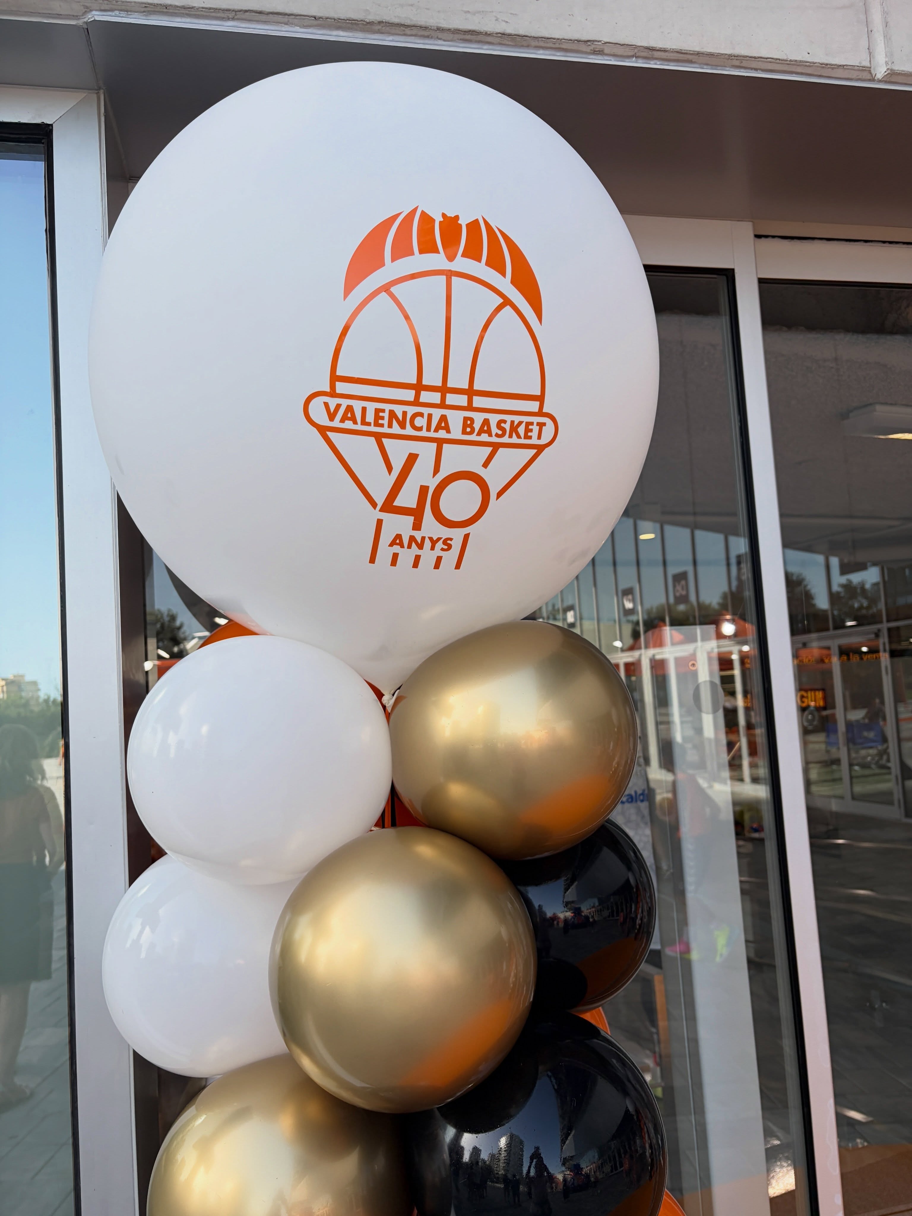 Detalle de globo blanco personalizado con el emblema naranja de Valencia Basket y globos dorados y negros