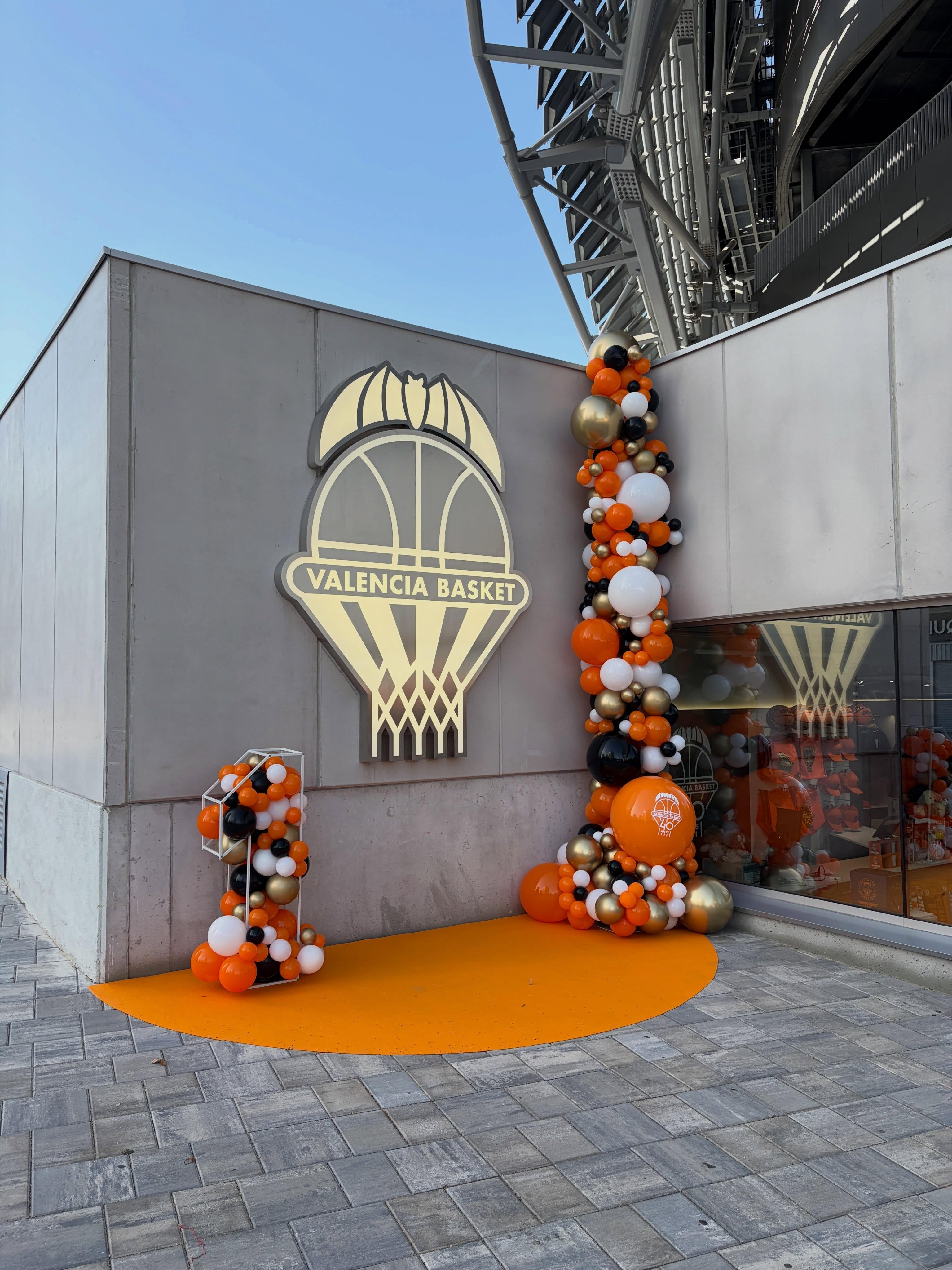 Photocall exterior de Valencia Basket con estructura en forma de 1 y guirnalda vertical de globos