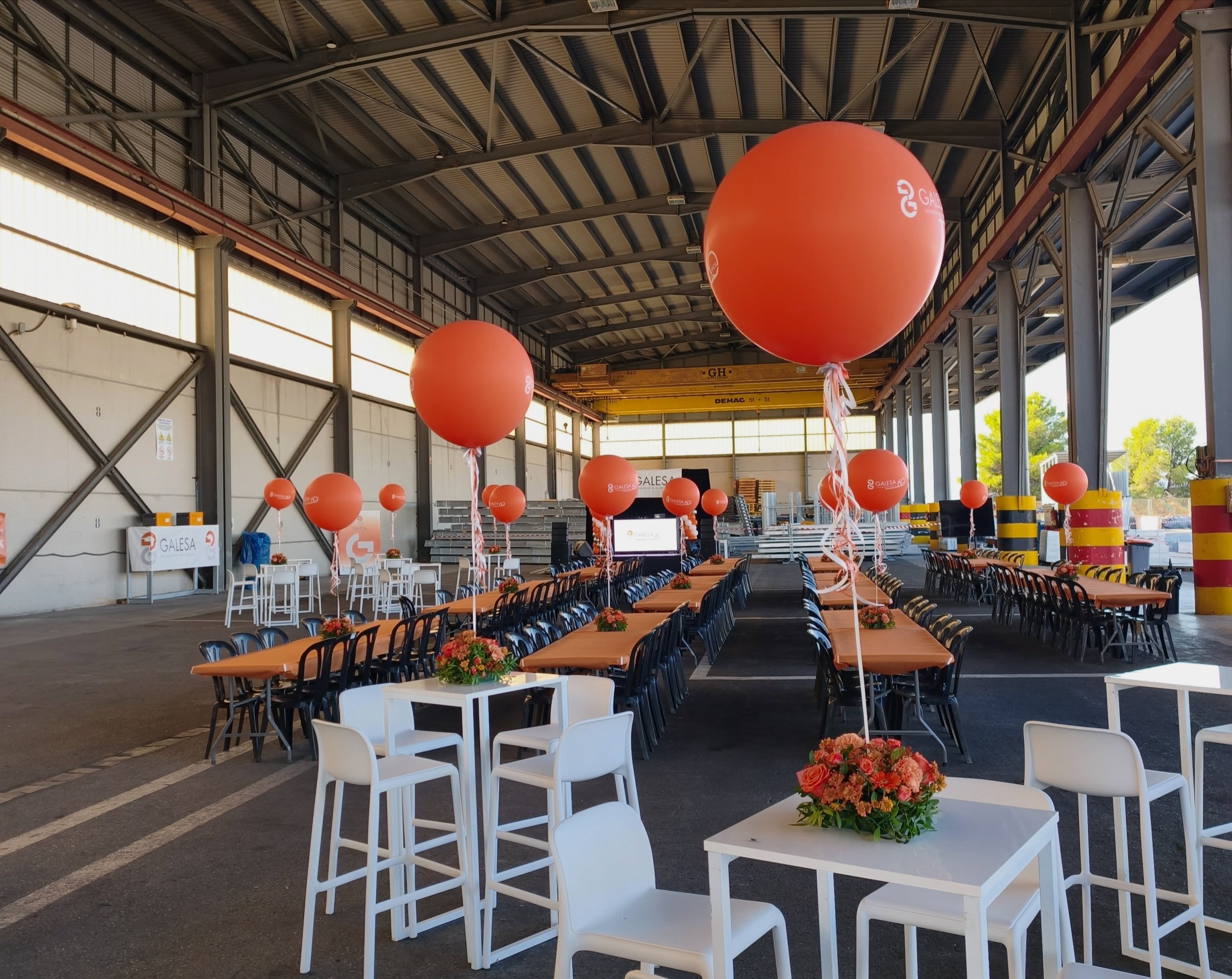 Espacio del Family Day de Galesa con mesas, centros florales y globos gigantes naranjas