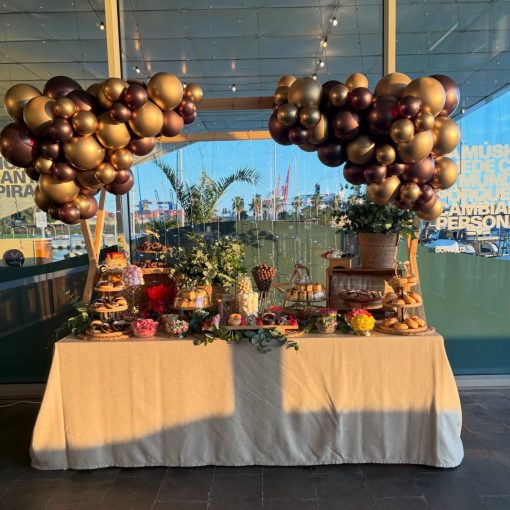 Mesa dulce de 18 cumpleaños enmarcada por globos chocolate y dorados en Veles e Vents